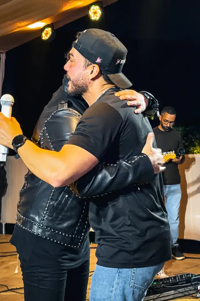 Léo Lira e Wesley Safadão se abraçam no palco.